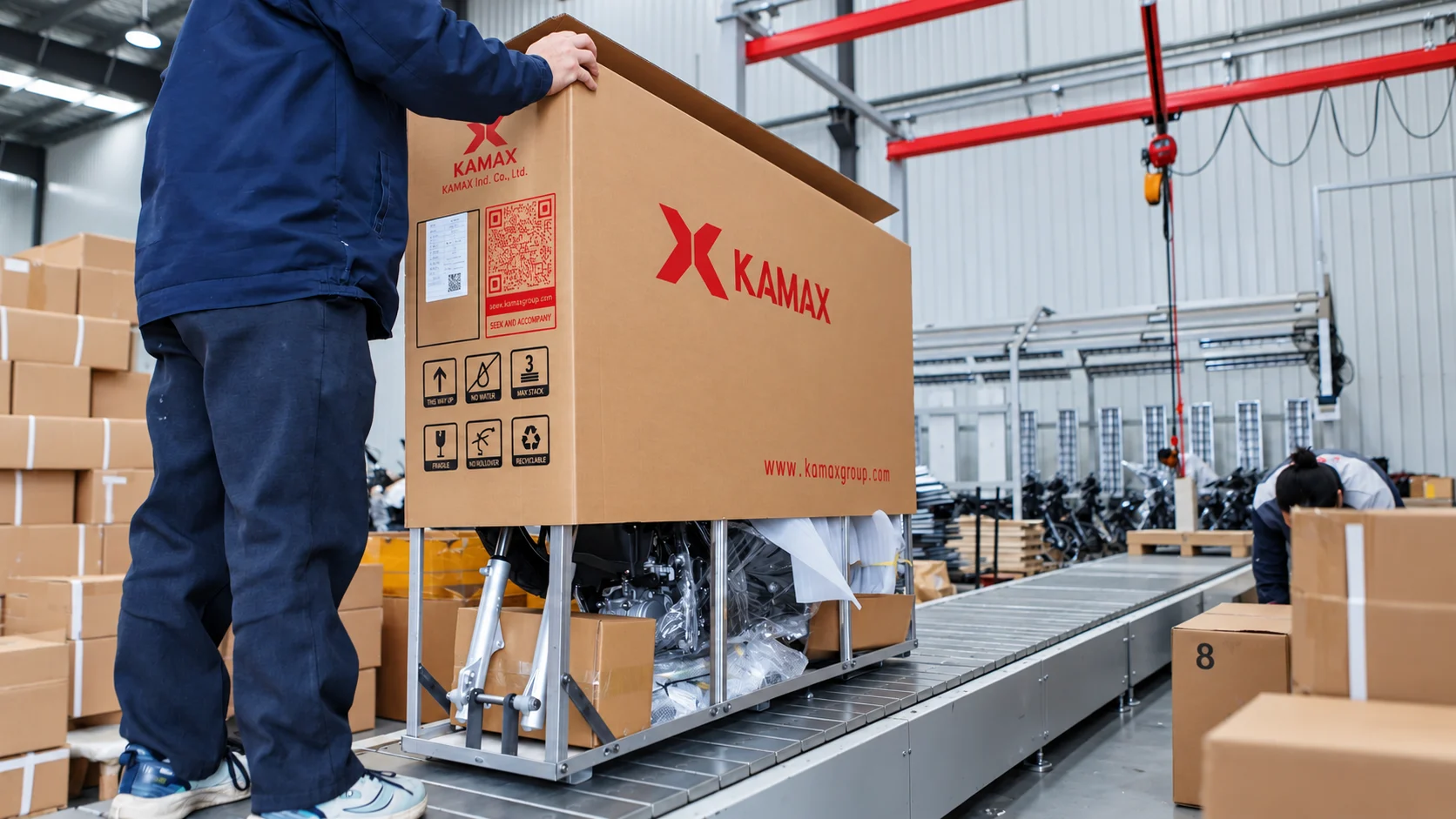 KAMAX factory worker performing SKD motorcycle packaging for export.